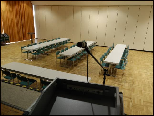 Blick auf die Bühne im Saal mit Mikrofonständer.